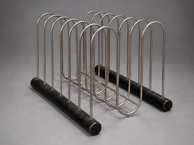 quatre tubes métalliques sont empilés les uns sur les autres sur une surface grise