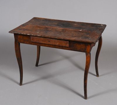 une vieille table en bois avec un tiroir en dessous, posée sur un sol gris