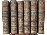 several old books stacked on top of each other in a row