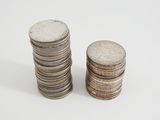 two stacks of coins sitting next to each other on a white surface