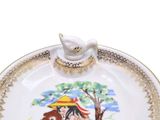 a plate with a bird on it and a bird sitting on top of it