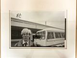 photographie en noir et blanc d'un homme debout devant un bus