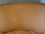 a close up of a brown leather chair in a room
