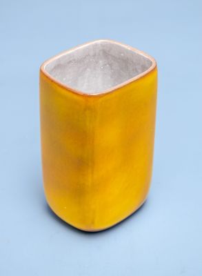 a yellow cup with a white rim sitting on a blue surface