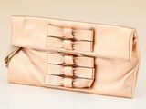 beige clutch bag with bow detail on the front