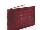 an old red book with writing on it sitting on top of a white surface