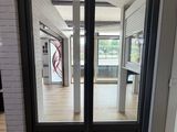 une double porte noire avec une vitre à l'extérieur