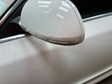 a side view mirror of a car with a reflection on the side of it