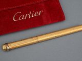 une image représentant un stylo doré et une pochette en velours rouge