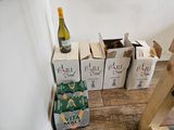 plusieurs cartons de vin et une bouteille de vin par terre