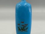 a blue vase that has a picture of flowers on it
