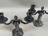 three silver candles are sitting on a white surface