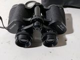 a pair of binoculars sitting on a table next to a pair of shoes