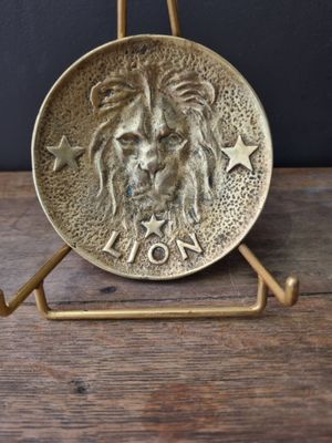 a close up of a metal plate with a lion on it