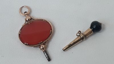 deux breloques posées sur une surface blanche