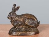 an image of a bronze statue of a rabbit on a wooden table