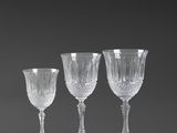 four wine glasses are lined up in a row on a black background