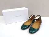 the green shoes are next to a white box on the table