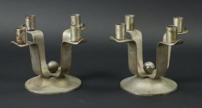 deux bougies en métal posées sur une table noire