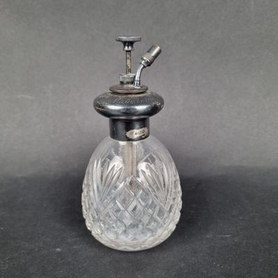 an old fashioned glass perfume bottle with a metal top