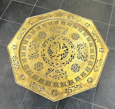 une assiette en or posée sur le sol carrelé