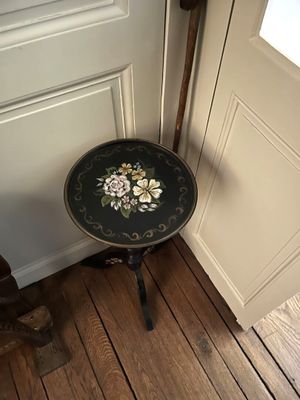une petite table ornée d'un motif floral, placée devant une porte