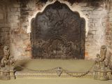 a stone fireplace with statues on it in a room