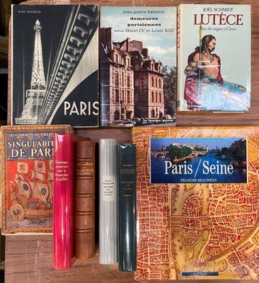 plusieurs livres posés sur une table sur laquelle se trouve une carte de Paris