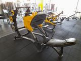 des appareils de fitness jaunes et noirs dans une salle de sport au sol noir