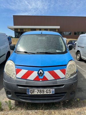 une petite camionnette bleue garée sur un parking