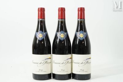 trois bouteilles de vin rouge posées l'une à côté de l'autre sur une surface blanche