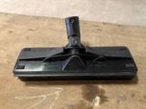 a black mop on a wooden table with a black handle