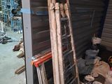 a ladder leaning up against a wall next to a pile of buckets
