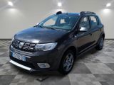 La Dacia noire est garée sur un sol en carrelage à damier.