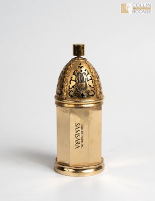 a small gold container with a label on it