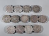 six different types of coins are arranged in a row on a white surface