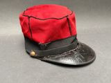 un chapeau rouge orné d'un ruban noir sur le dessus