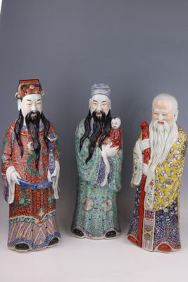 three chinese figurines of men with long hair and beards