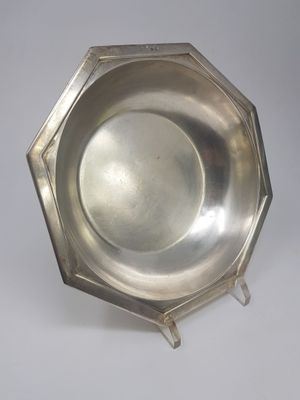 an antique silver plate on a stand on a white background