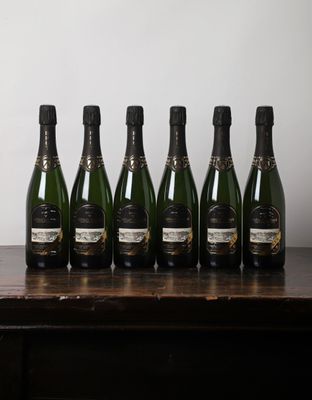 six bouteilles de champagne alignées sur une table en bois