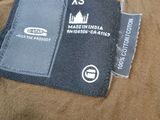 a label on the back of a jacket that says xs