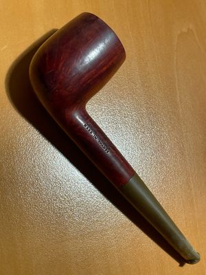 une pipe posée sur une table à côté d'une tasse