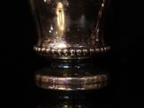 a close up of a silver cup on a black surface