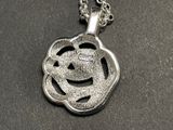 a silver necklace with a smiley face on it
