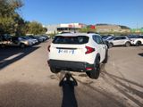 a white car parked in a parking lot with other cars