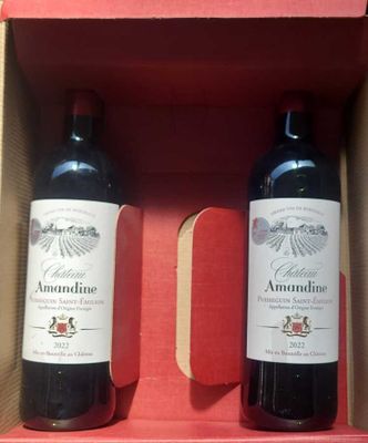 two bottles of red wine in a box on a table