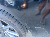 a man standing next to a car that has a tire on it