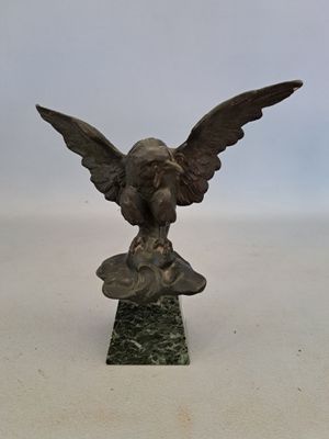 une image représentant une statue en bronze d'un aigle sur un socle