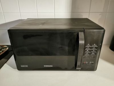 a black microwave sitting on a counter in a kitchen