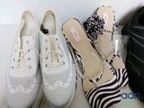 several pairs of shoes are lined up on a shelf next to a bag